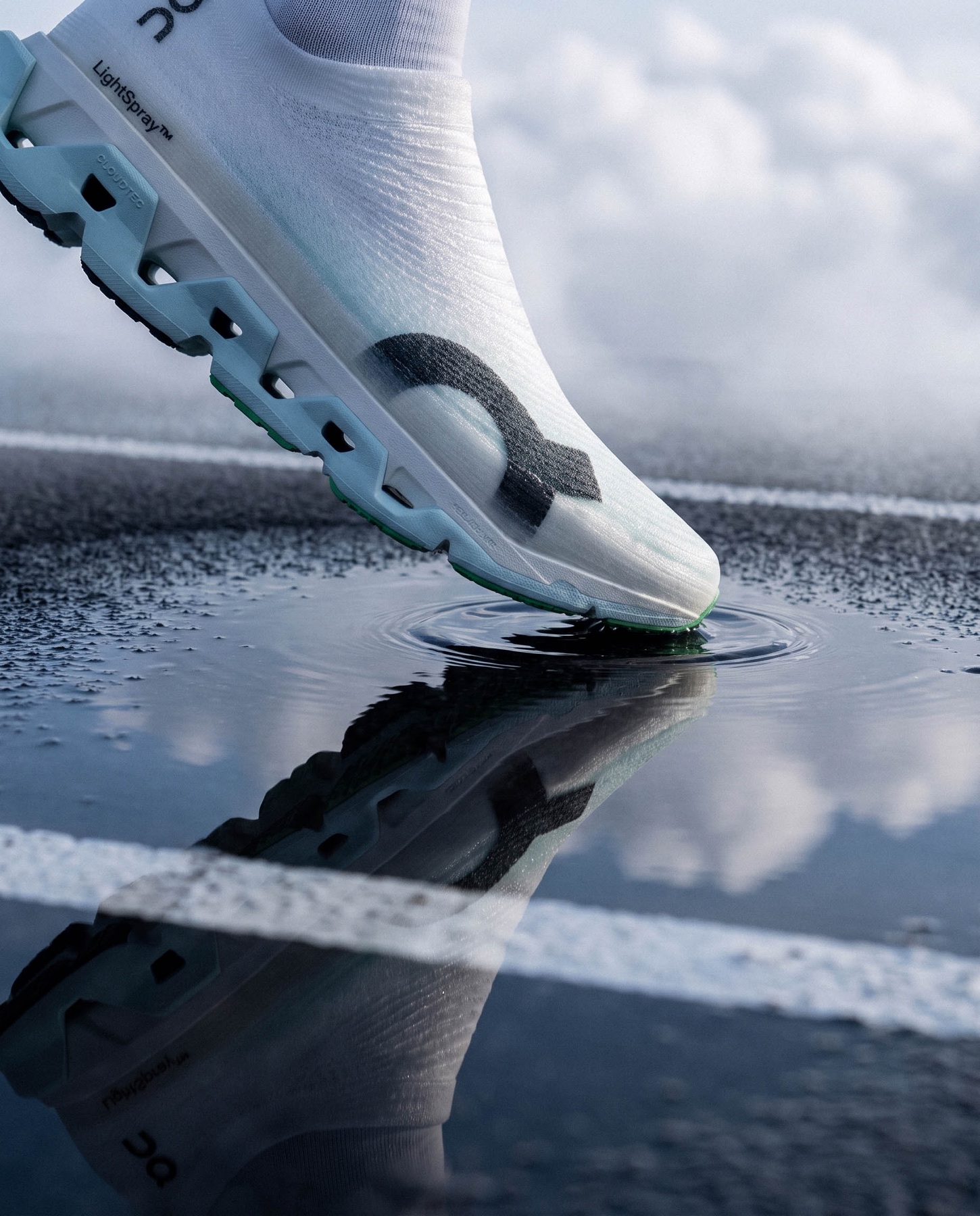 Close-up van een hardloopschoen boven een waterplas met reflectie