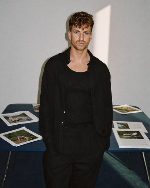 Boyd van Kaauwen in the studio, campaign prints laid out behind him